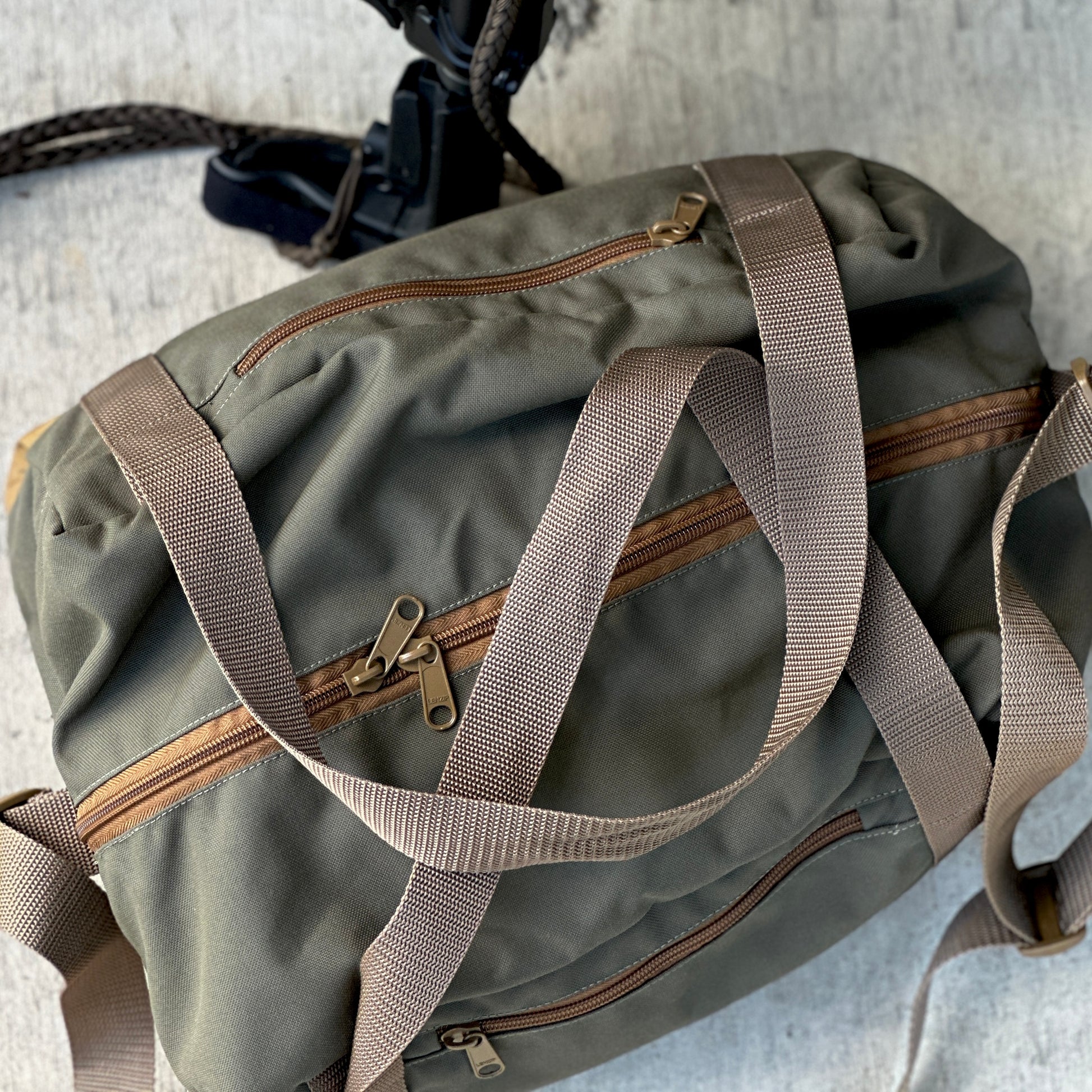 Recon 30L duffel bag in olive green with dual zippers and adjustable straps.